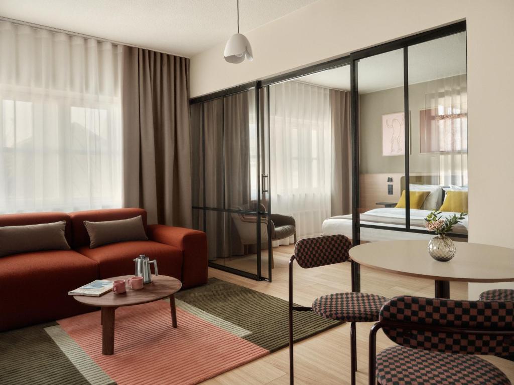 a living room with a couch and a table at Bob W Helsinki Kaarti in Helsinki
