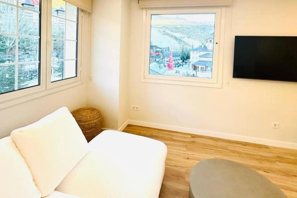 シエラネバダにあるApartment Salvia Plaza Andalucíaの白いソファと薄型テレビのあるリビングルーム