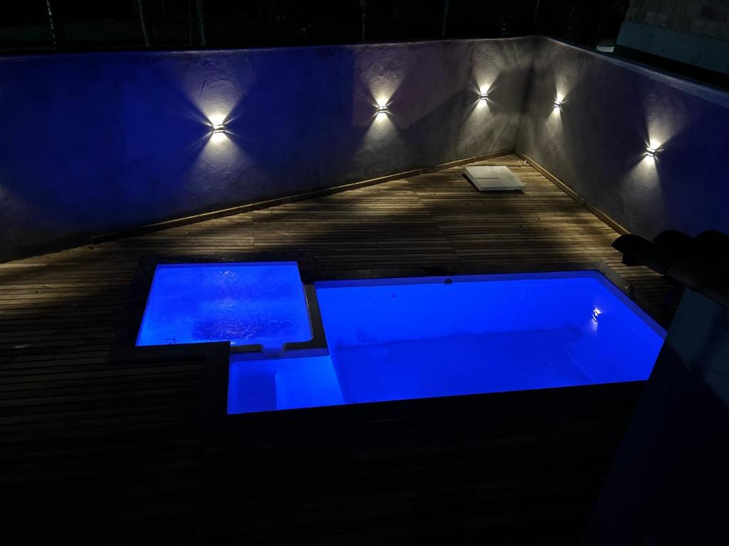 a dark room with a tub with blue lights at Su House Suíte Arraial dAjuda in Porto Seguro