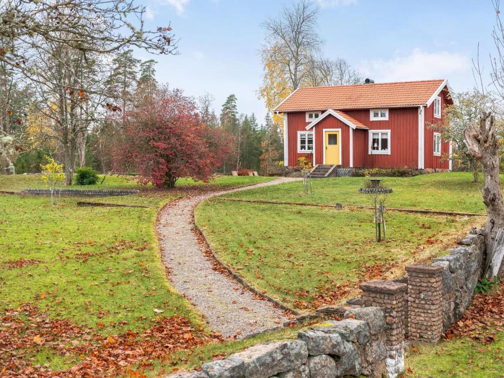 a red house with a stone path in front of it at Holiday Home Mjuamåla by Interhome in Eringsboda