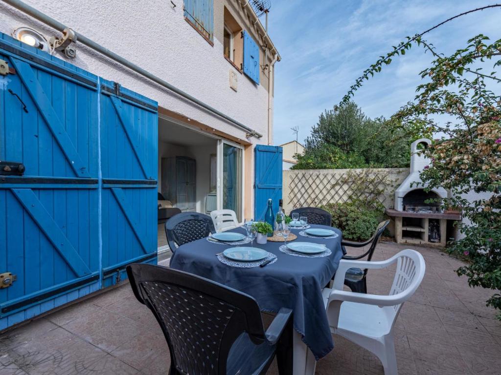 une table avec un chiffon bleu sur une terrasse dans l'établissement Holiday Home Les Jardins du Barcarès-1 by Interhome, au Barcarès