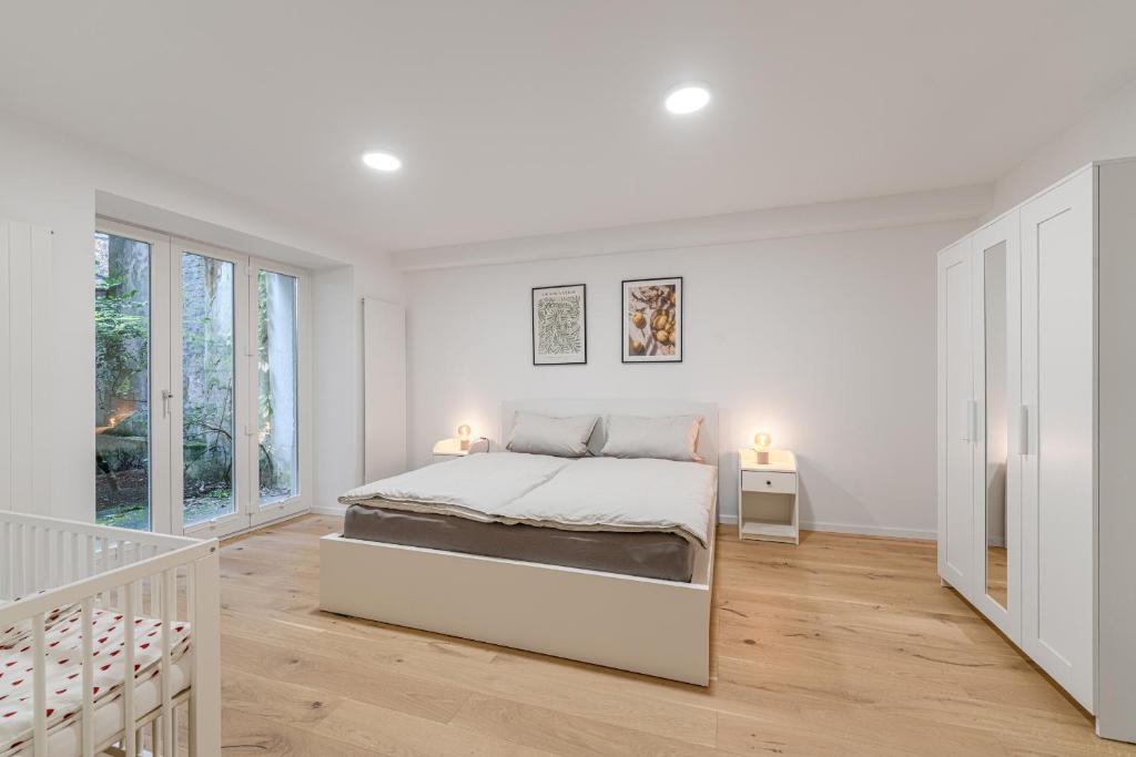 Un dormitorio blanco con una cama y una escalera. en Wohnung in Toplage in Düsseldorf-Oberkassel, en Düsseldorf