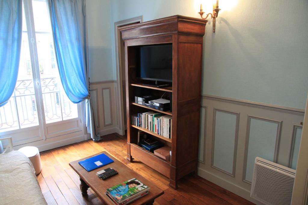 a living room with a tv and a book shelf at Apartment Lourmel in Paris