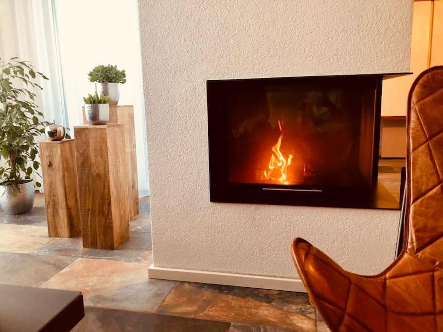 a living room with a fireplace in the wall at Ferienhaus Belvedere am Schluchsee in Schluchsee
