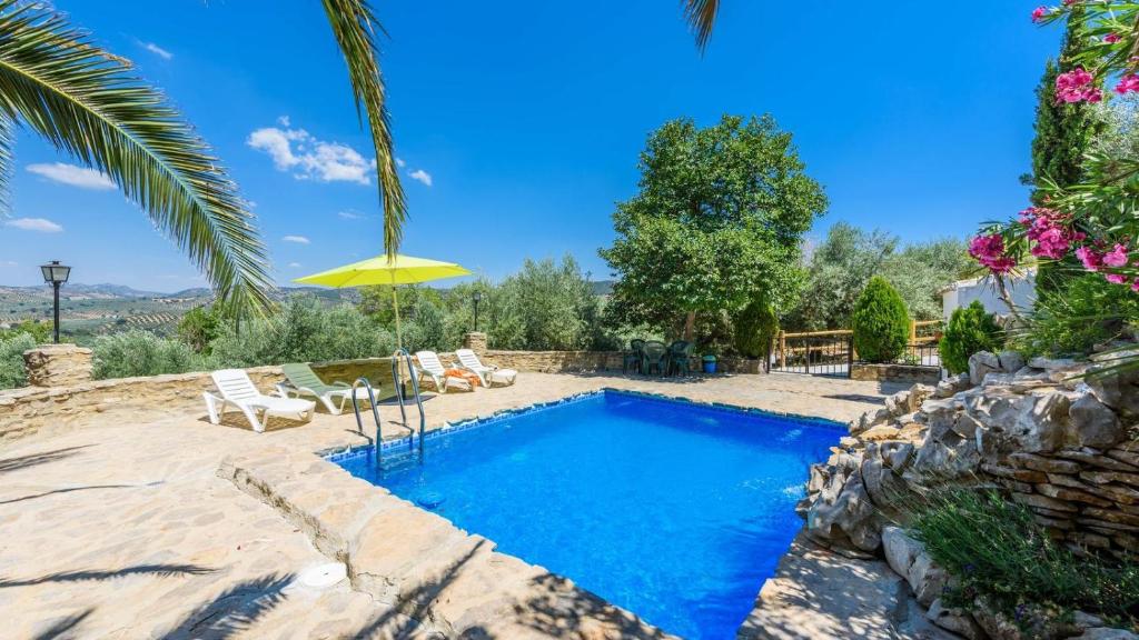 a swimming pool in a yard with a palm tree at Cortijo Casablanca Priego de Cordoba by Ruralidays in Priego de Córdoba