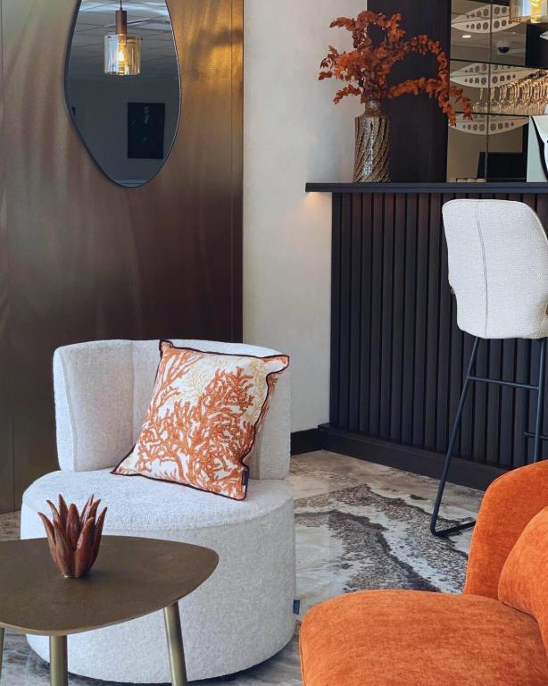 un salon avec une chaise et une table dans l'établissement Hôtel Breizh Du Golfe, à Arzon