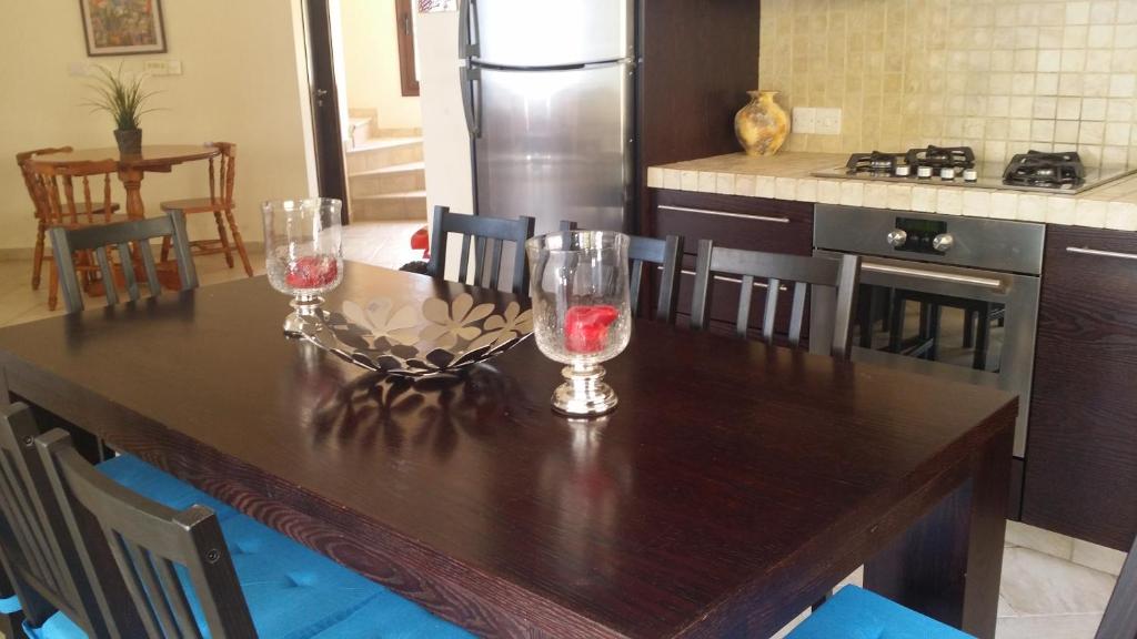 a kitchen table with two wine glasses on it at Villa Bella Vista in Drousha