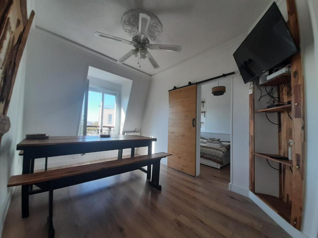 - un salon avec une table et un ventilateur de plafond dans l'établissement Appartement 3 pièces Gare de Lyon Bercy Arena 75012 Paris, à Paris