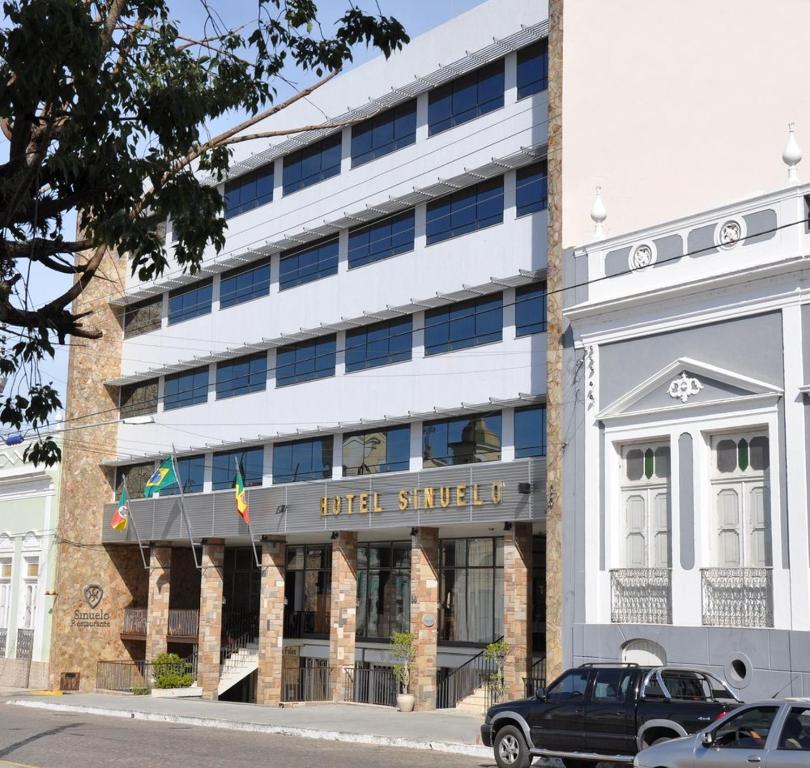 a building with a truck parked in front of it at Hotel Sinuelo in Jaguarão