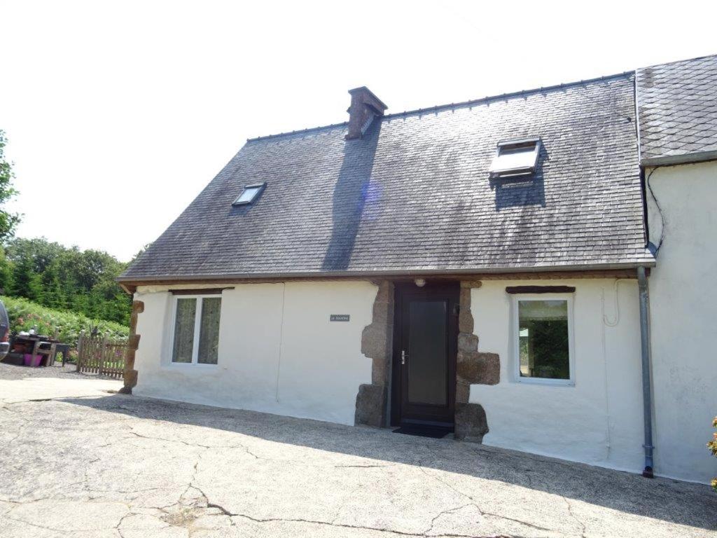 une maison avec un garage blanc et un toit dans l'établissement La sourdine, à Sourdeval