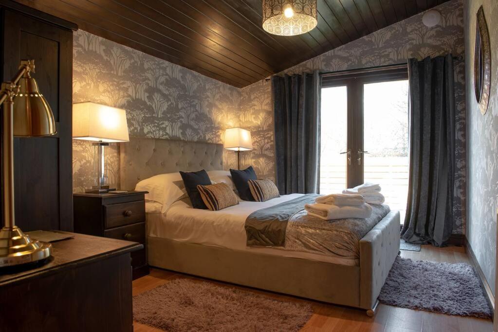 a bedroom with a large bed and a window at Clover 20 Lodge, Yellowtop Country Park in Selby