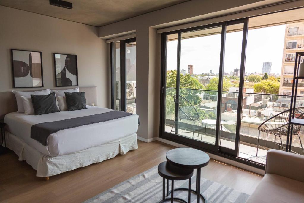 a bedroom with a bed and a large window at Milenia Soho by iPPA in Buenos Aires