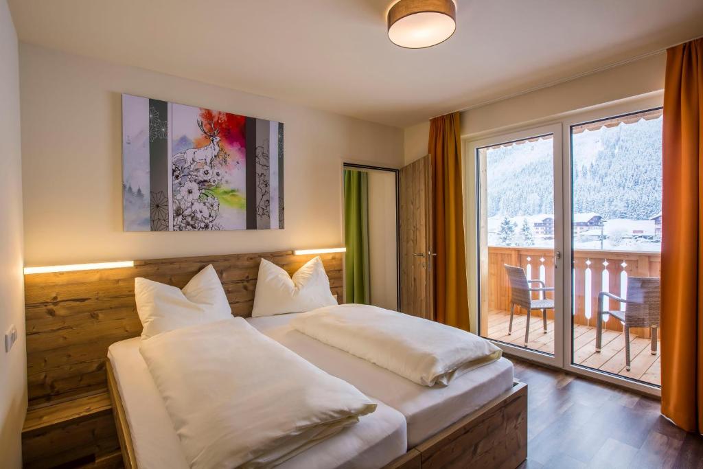 Uma cama ou camas num quarto em COOEE alpin Hotel Dachstein