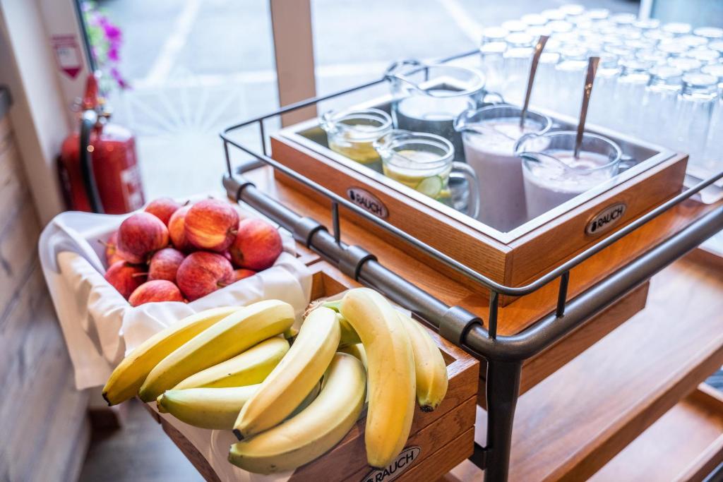 uma bandeja de bananas e outras frutas sobre uma mesa em COOEE alpin Hotel Dachstein em Gosau