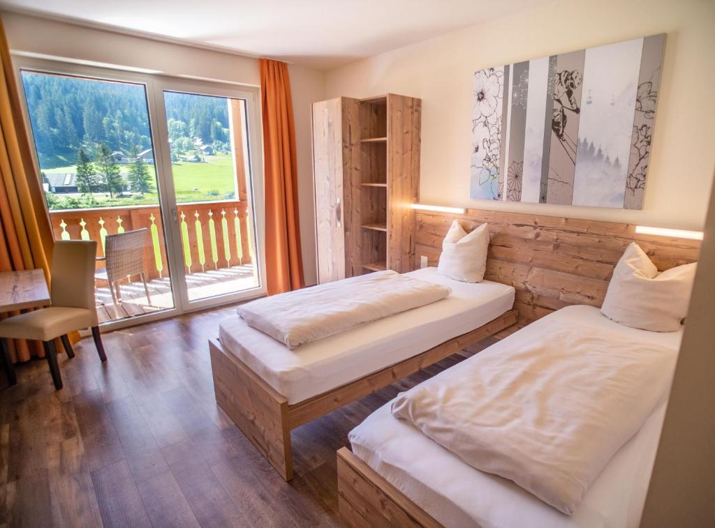 Uma cama ou camas num quarto em COOEE alpin Hotel Dachstein
