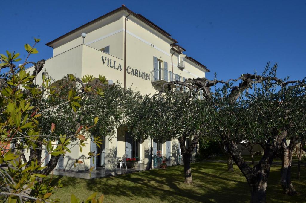 a white building with trees in front of it at Residence Villa Carmen fronte mare a 50 mt in Pietra Ligure