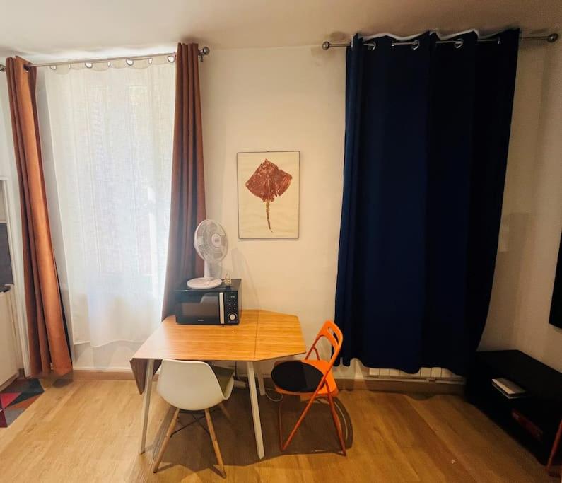 a room with a table with a radio and two chairs at Beau studio au coeur du Panier in Marseille