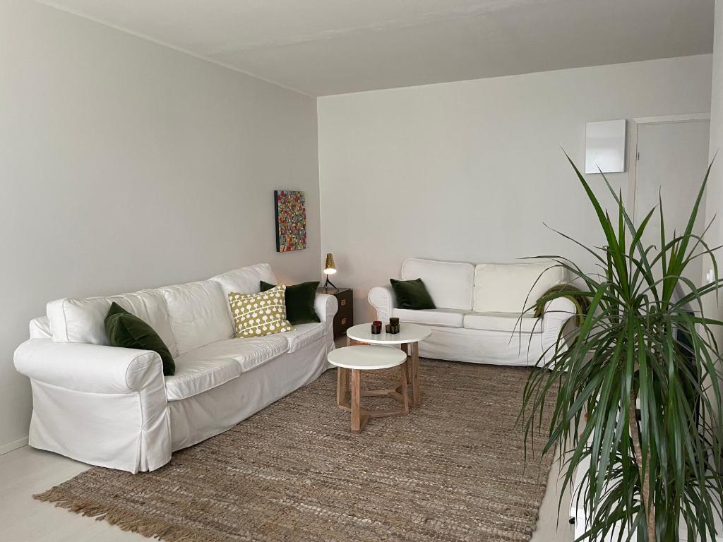 a living room with a white couch and a table at Valoisa kaksio puiston reunassa lähellä keskustaa in Hanko
