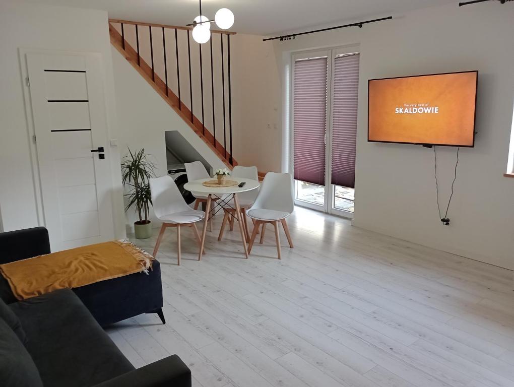 a living room with a tv and a table and chairs at Skalny domek in Krościenko