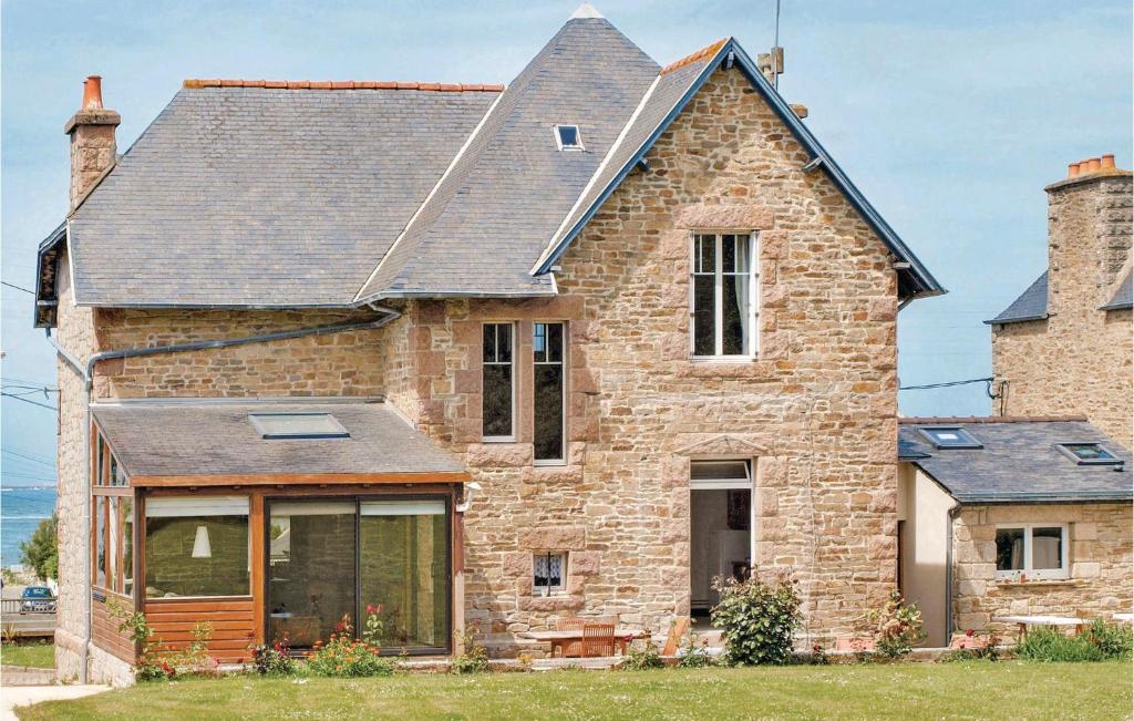 an old brick house with a large window at Holiday Home Hent Gwaz Ar Gouez in Locquémeau