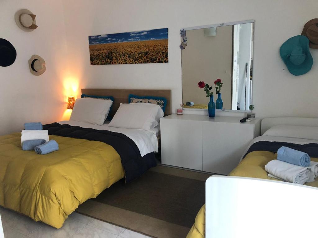 una camera con due letti con lenzuola gialle e una finestra di Monolocale Liola a Mestre