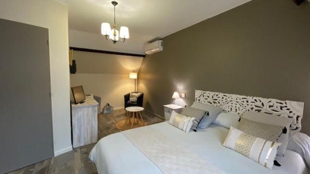 a bedroom with a large white bed and a chair at LA MAISON DE TRIBOULET Chambres et table d'hôtes -Amboise- in Pocé-sur-Cisse