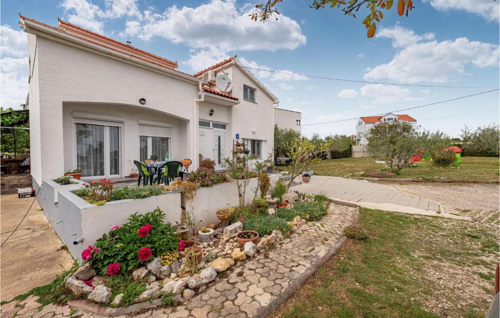 una casa con un jardín de flores delante de ella en Cozy Apartment In Vrsi With Wifi, en Vrsi