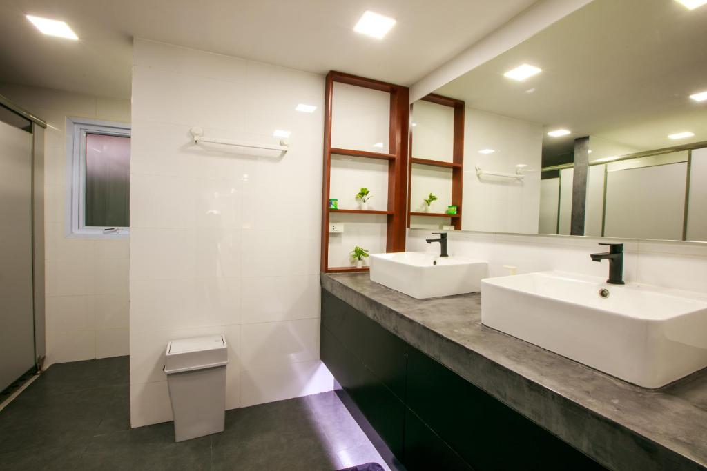 a bathroom with two sinks and two mirrors at Lafami Hostel in Ban Nongdouang