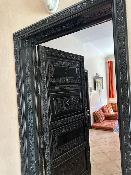 a black door in a room with a living room at Tradition & Tranquility in Tamraght Ouzdar