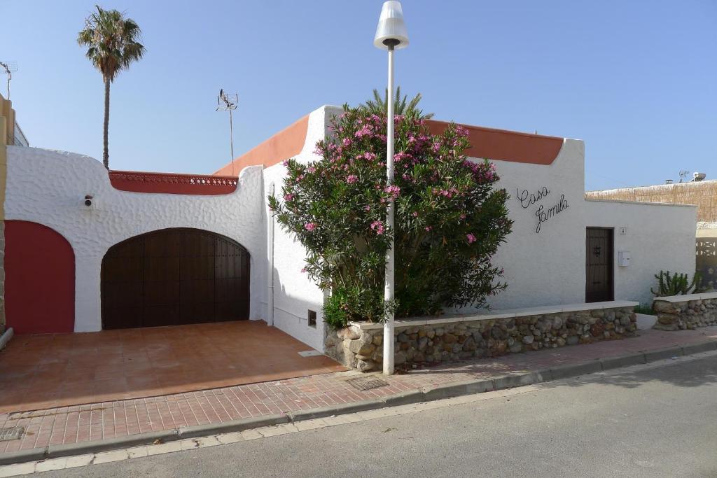 a white building with a garage and a tree at Casa Jamila in El Alquián
