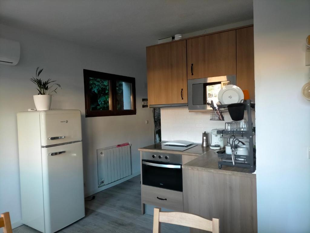 a kitchen with a white refrigerator and a stove at Apartamento rural con vistas in Miraflores de la Sierra
