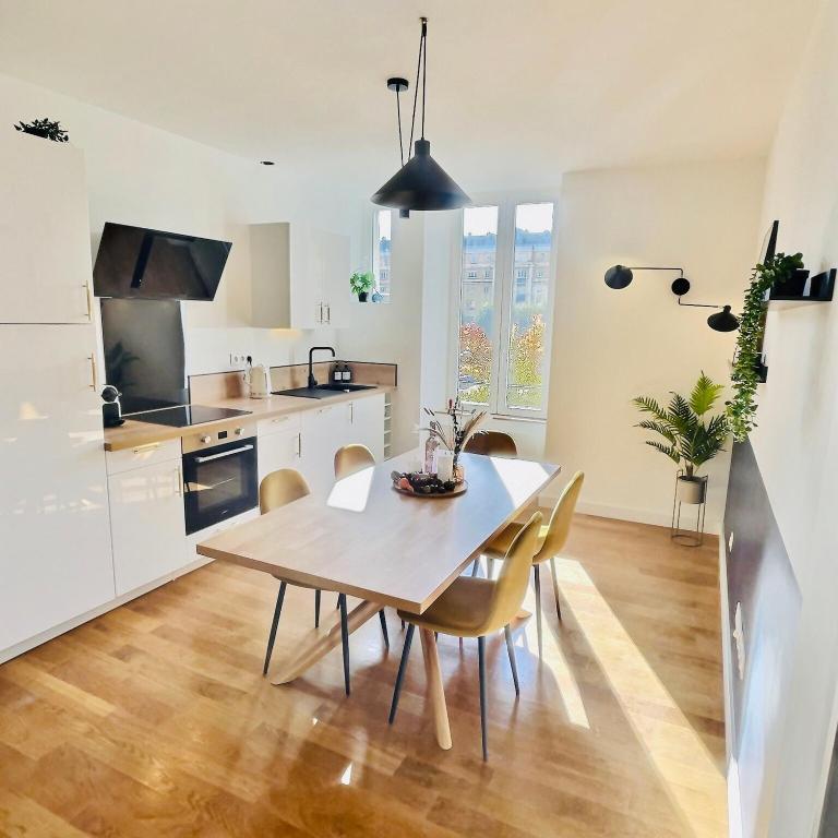 une cuisine et une salle à manger avec une table et des chaises dans l'établissement 201 - Appartement confortable face à la Maison du Peuple, à Belfort