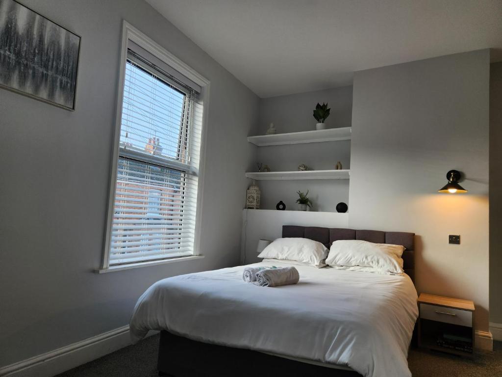 a bedroom with a large white bed with a window at Beautiful stylish house near town centre in Rugby