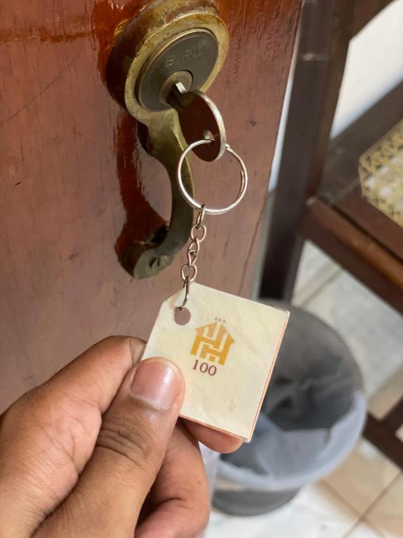 a person holding up a key to a door at Suriya Haven Homestay in Badulla