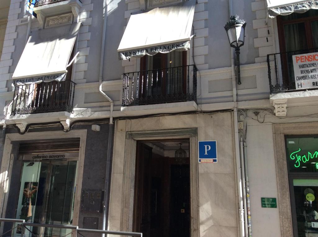 un edificio con balcones y una señal de aparcamiento en una calle en Pensión Princesa, en Granada