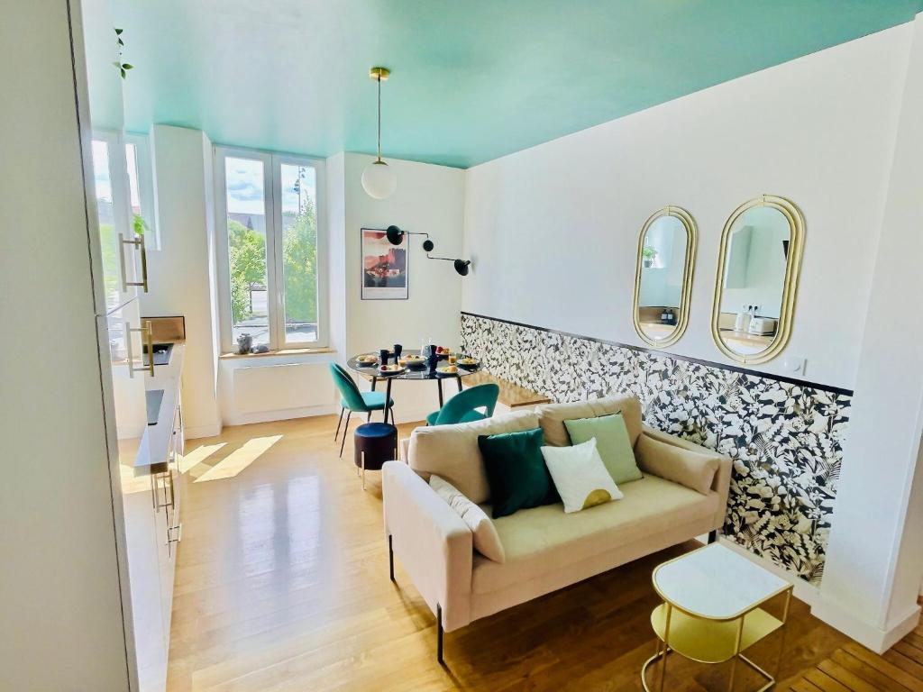 a living room with a couch and a table at 101 - Appartement élégant art déco près du centre ville in Belfort