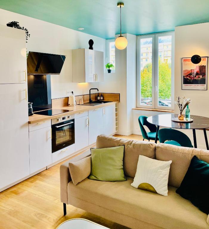 un salon avec un canapé et une cuisine dans l'établissement 101 - Appartement élégant art déco près du centre ville, à Belfort