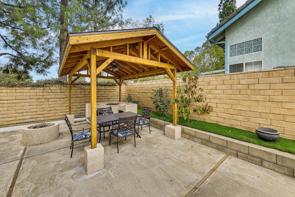 Un pabellón de madera con una mesa y sillas en un patio. en Covered Patio with Grill Home in Rancho Cucamonga!, en Rancho Cucamonga