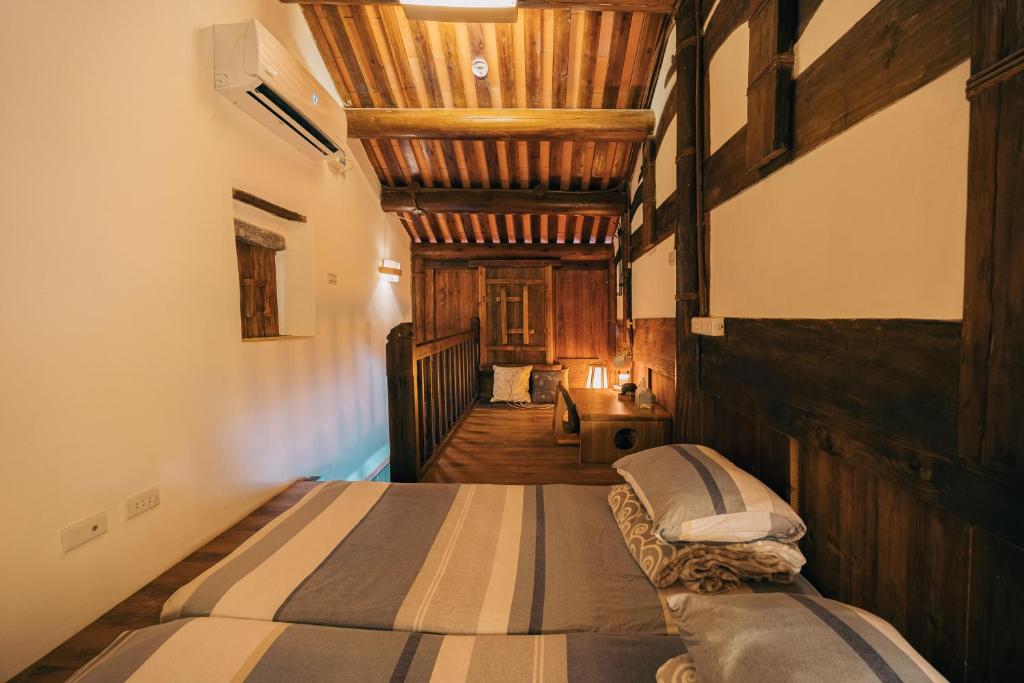 Postel nebo postele na pokoji v ubytování 新龍頭古厝本館 Shin Long Tou B&B