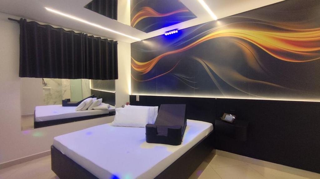 Un dormitorio con dos camas y un cuadro en la pared. en Vem Para o - Motel Marselha 2, en São Paulo