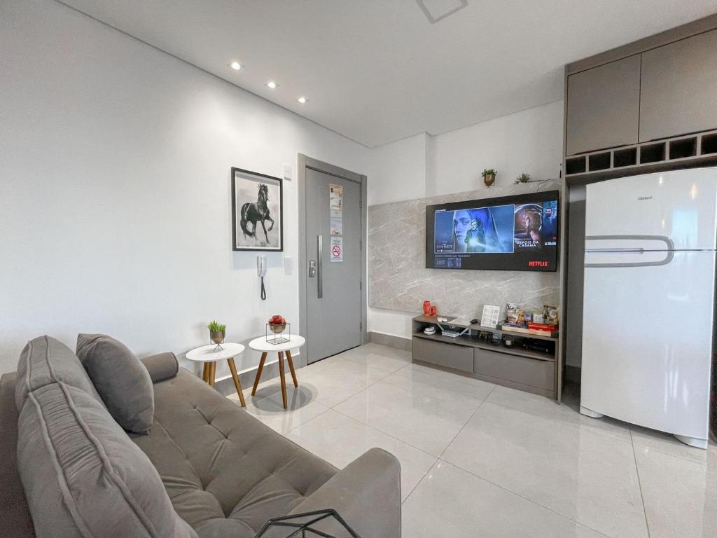 a living room with a couch and a tv at A Melhor Vista de Campo Grande in Campo Grande