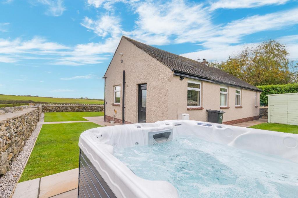 a hot tub in the backyard of a house at Colt Park Cottage in Ulverston