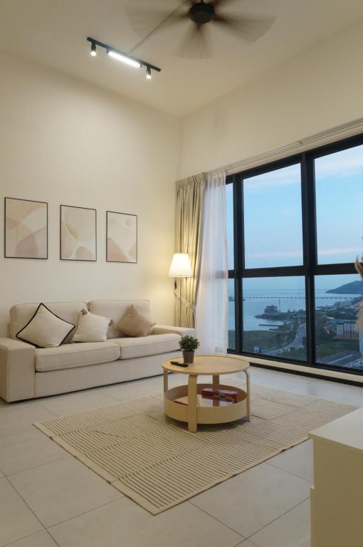 a living room with a couch and a table at Urban Suites Seaview 3Bedrooms 2Carparks 8pax in Jelutong