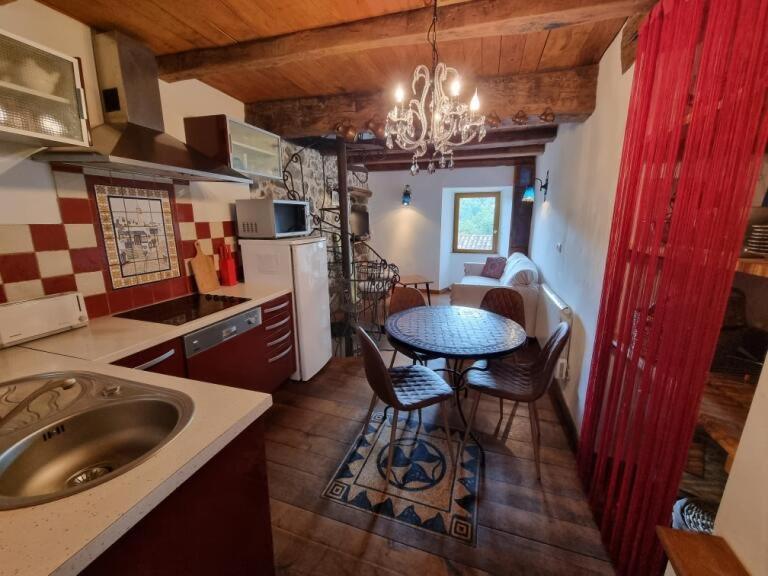 a kitchen with a table and chairs in a room at mare-monte in Evisa