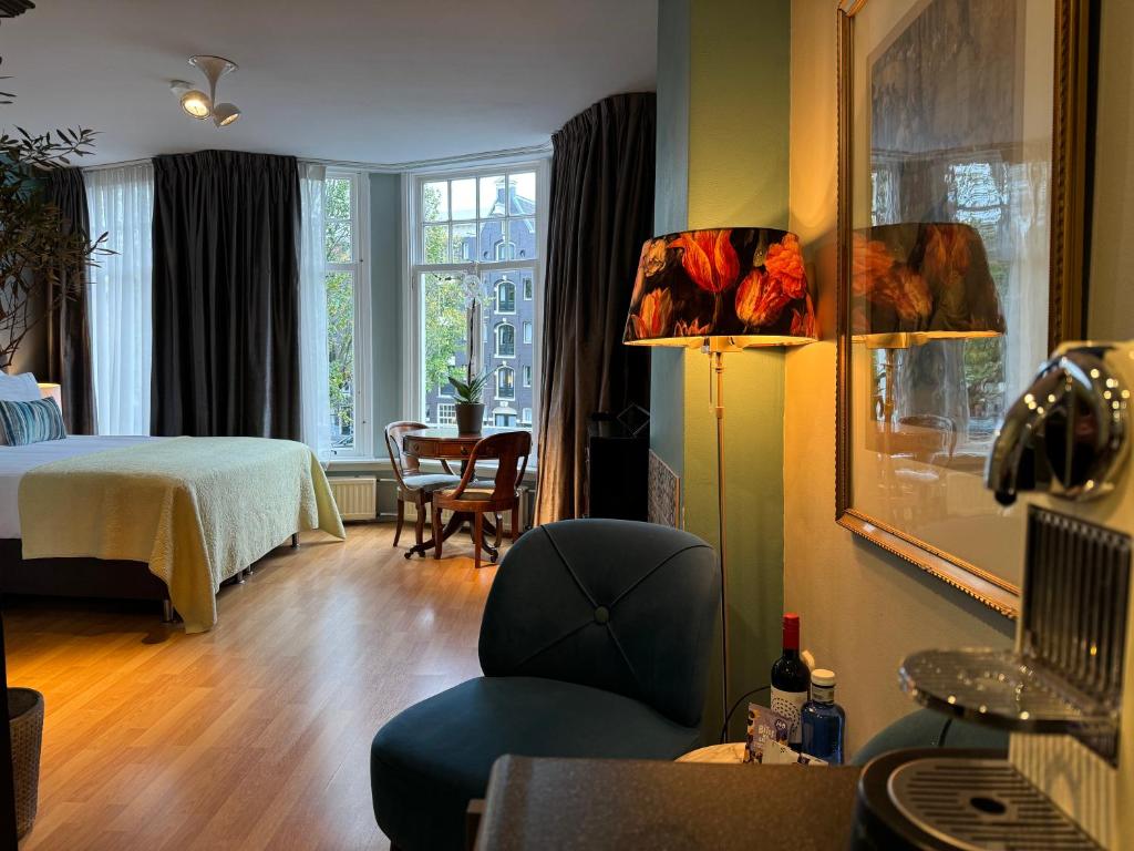 a living room with a bed and a chair in a room at Décor Canal House in Amsterdam