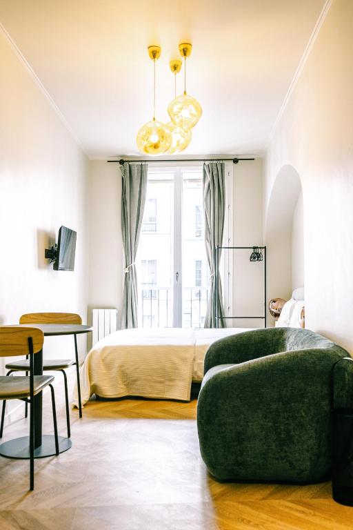 une chambre avec un lit et un canapé vert dans l'établissement Studio Design Neuf - Central, à Paris