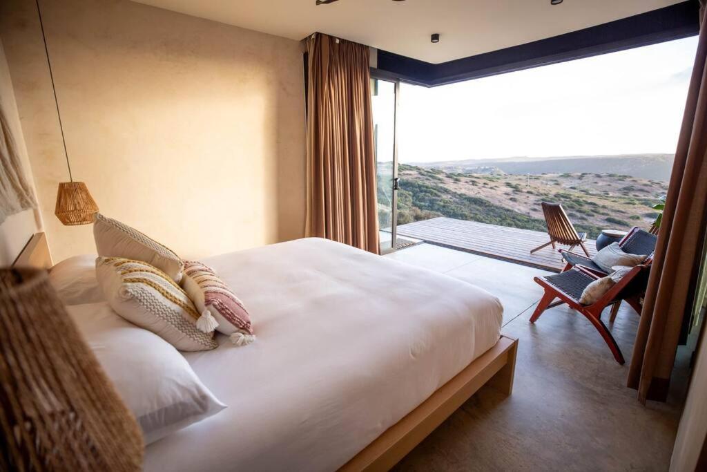 een slaapkamer met een groot bed en een groot raam bij Nubla Residence villa Uno in Ensenada
