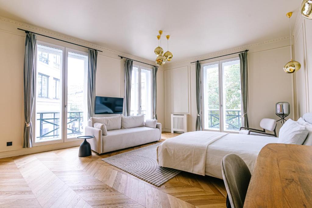 une chambre avec un grand lit et un canapé dans l'établissement Luxurious Paris Loft Near Opéra, à Paris