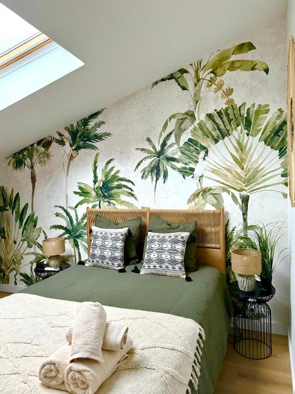 - une chambre avec un lit orné d'une fresque murale de palmiers dans l'établissement Au Golden Duplex - Centre - Clim - Parking, à Narbonne