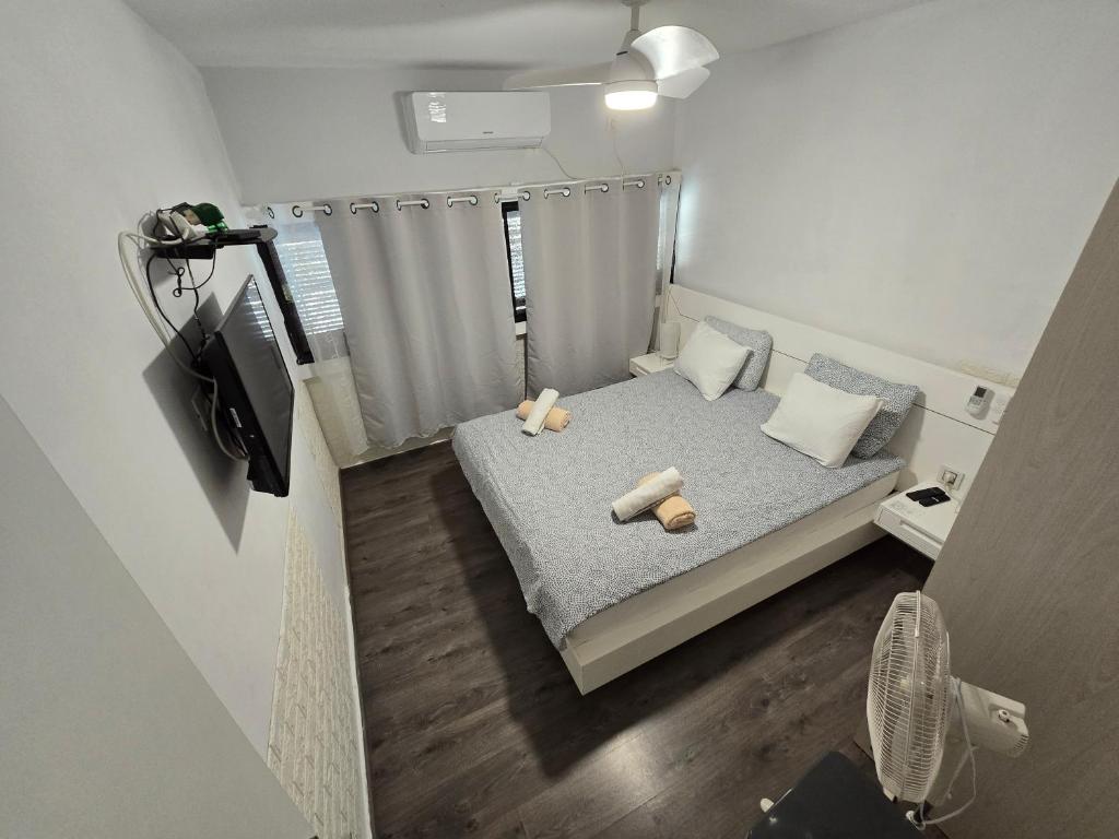 a small bedroom with a bed with two teddy bears on it at Neviot in Eilat